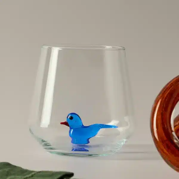 Drinking glass with bird figurine